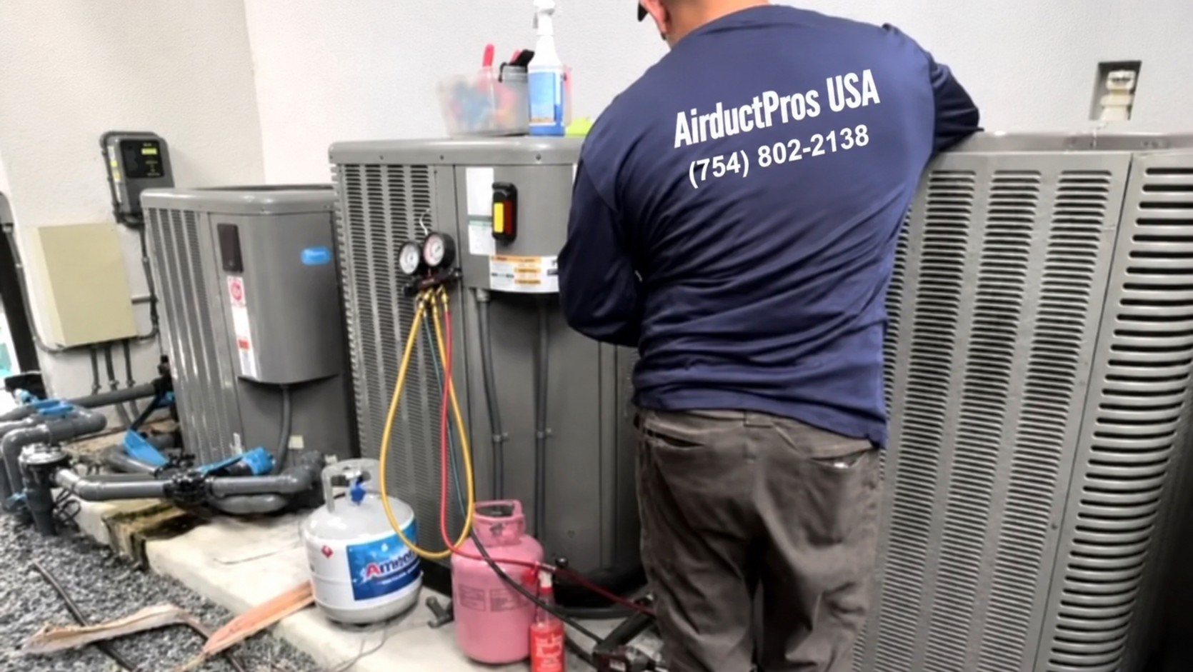 Air Duct Pros USA technician performing commercial AC repair on rooftop — full view